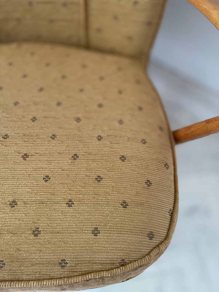Close-up of a mustard cushion with a subtle pattern on a white background