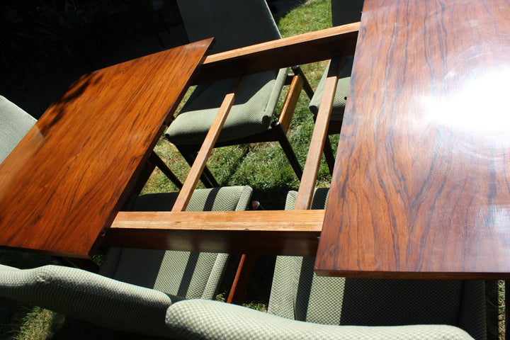 Elegant mid-century dining set featuring a Hamilton table with Danish rosewood finish and matching chairs by Archie Shine