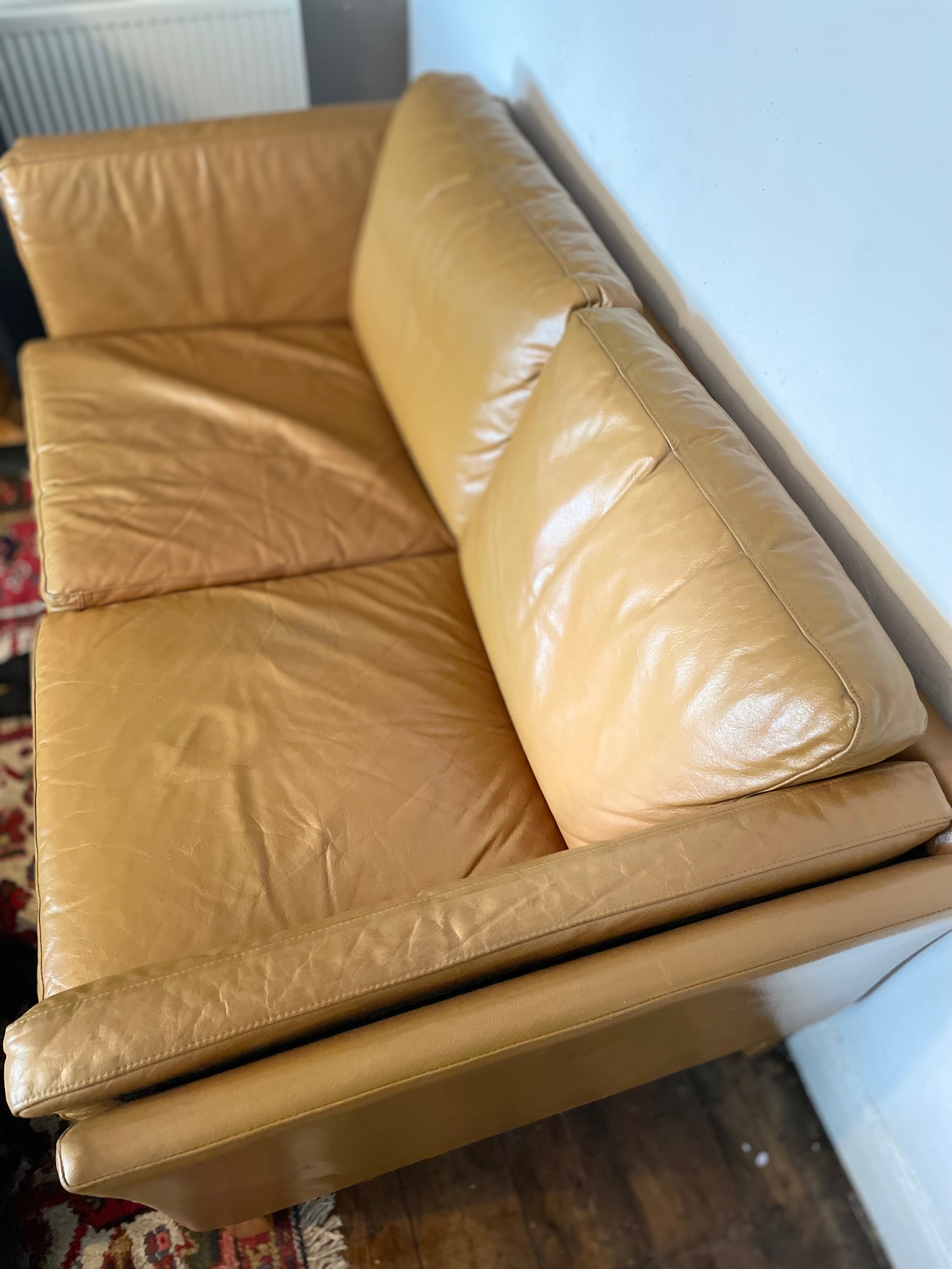 Tan Leather sofa with white background and antique rug