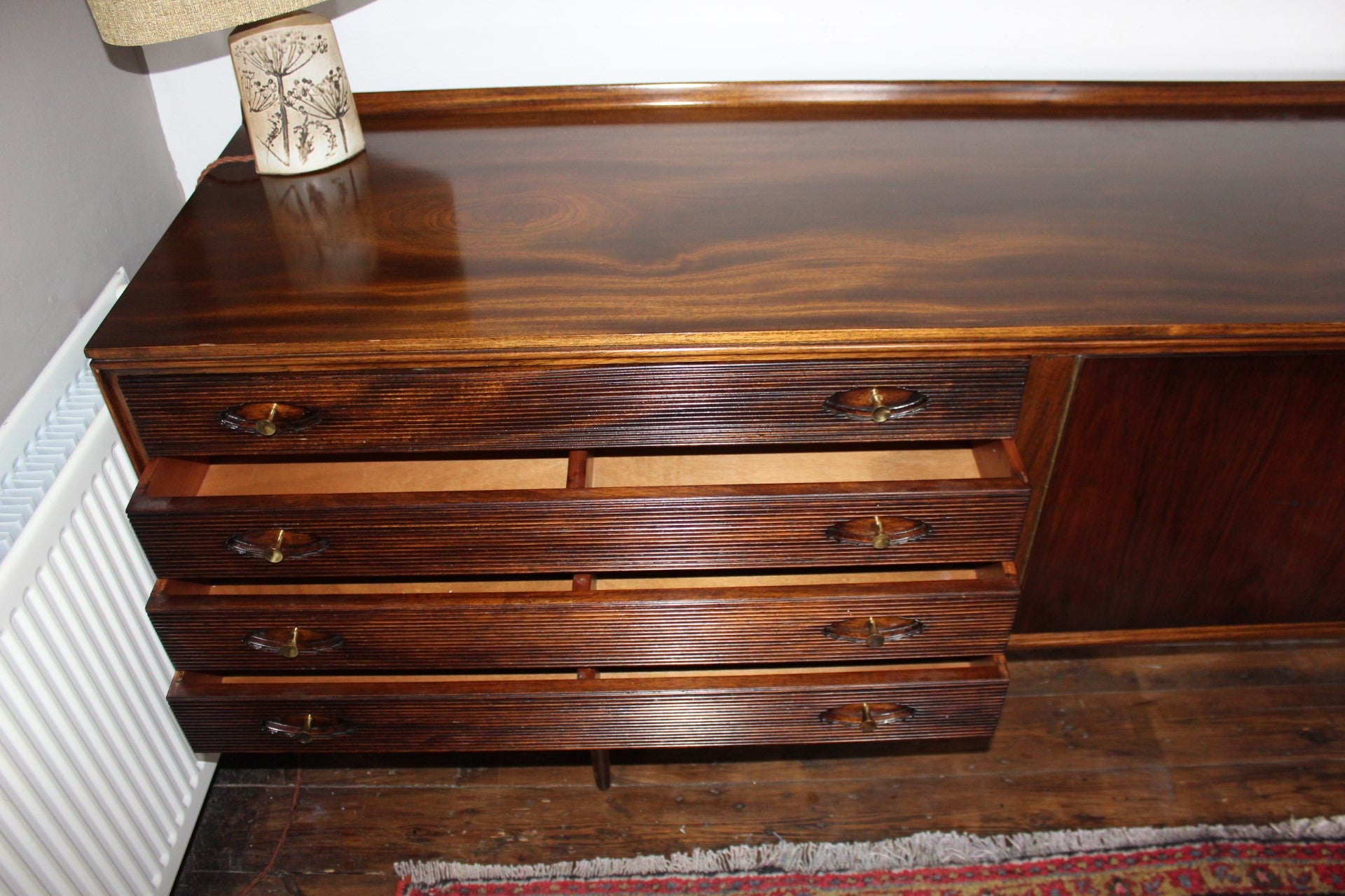 Mid century sideboard featuring turned wooden trumpet pulls and elegant detailing