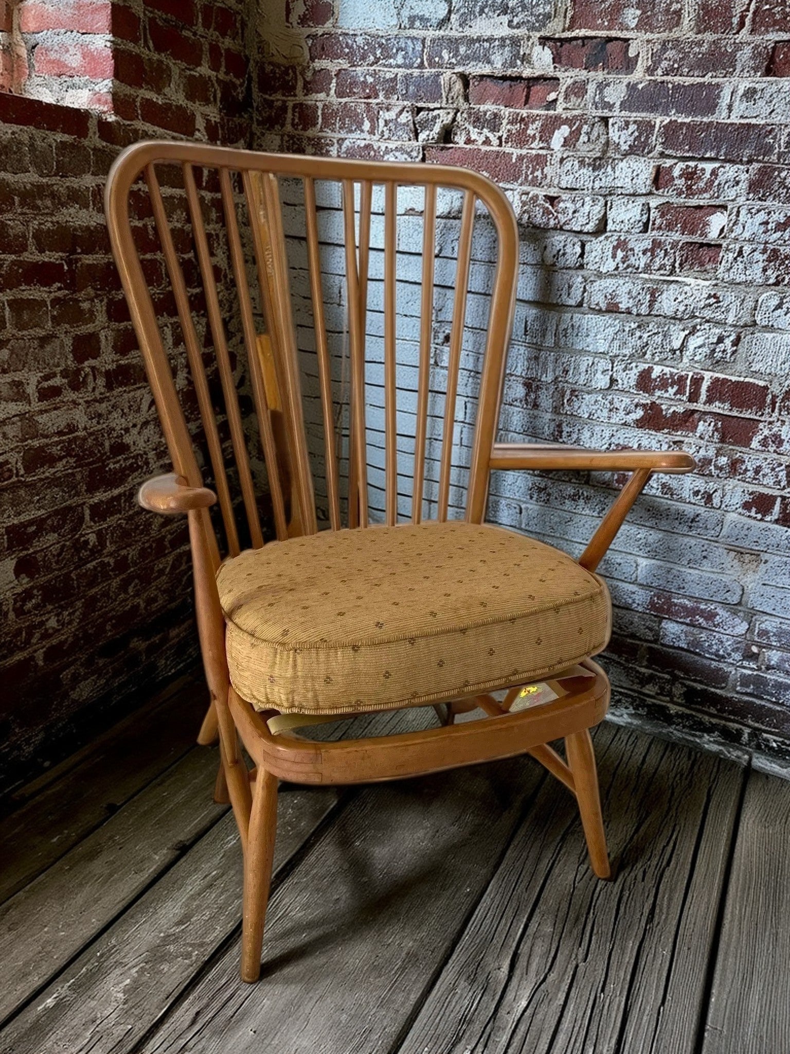 Wooden Ercol high back grandfather armchair in a room setting