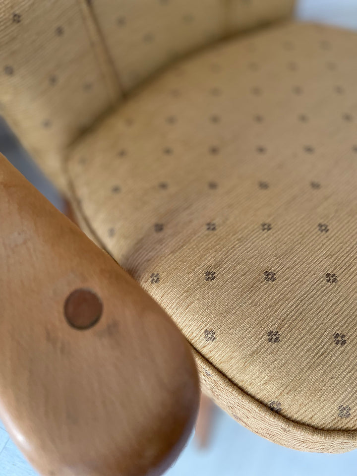 Close-up of a wooden spoon and beige cushion with a subtle pattern