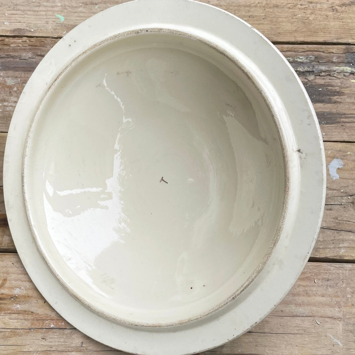 round off-white ceramic bowl with a wide rim, photographed from directly above on a rustic wooden plank surface.
Details