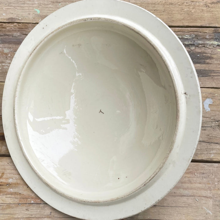 round off-white ceramic bowl with a wide rim, photographed from directly above on a rustic wooden plank surface.
Details
