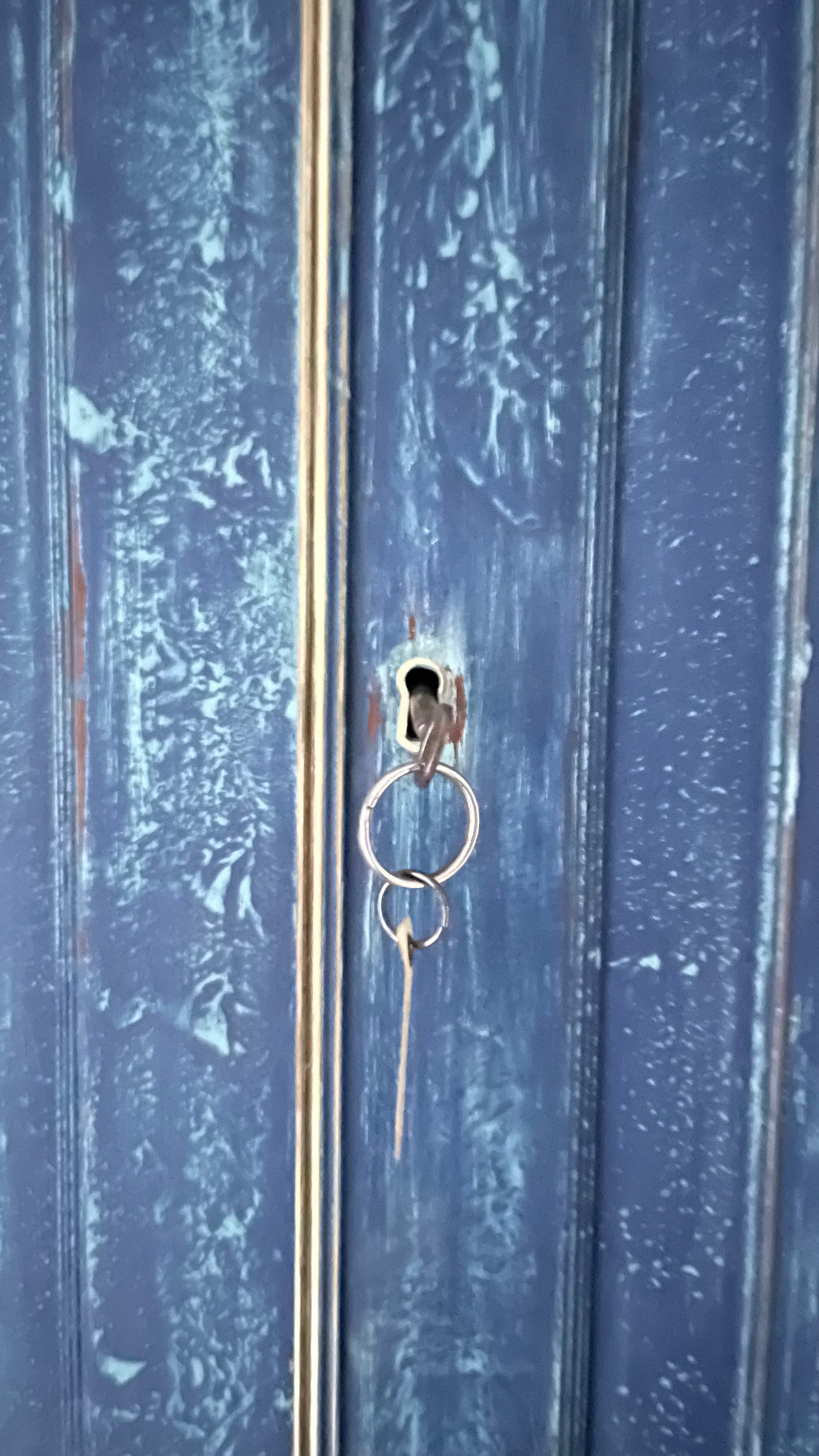 Blue painted linen press close up of brass keyhole