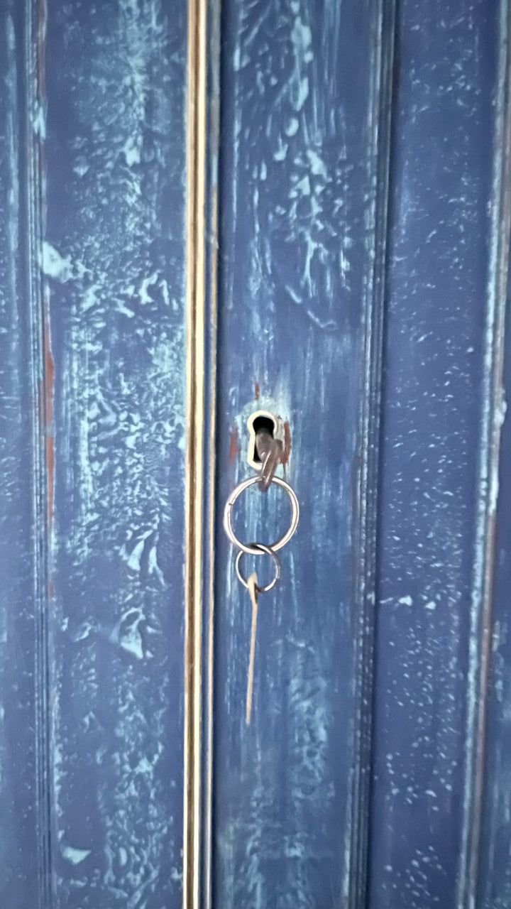 Blue painted linen press close up of brass keyhole
