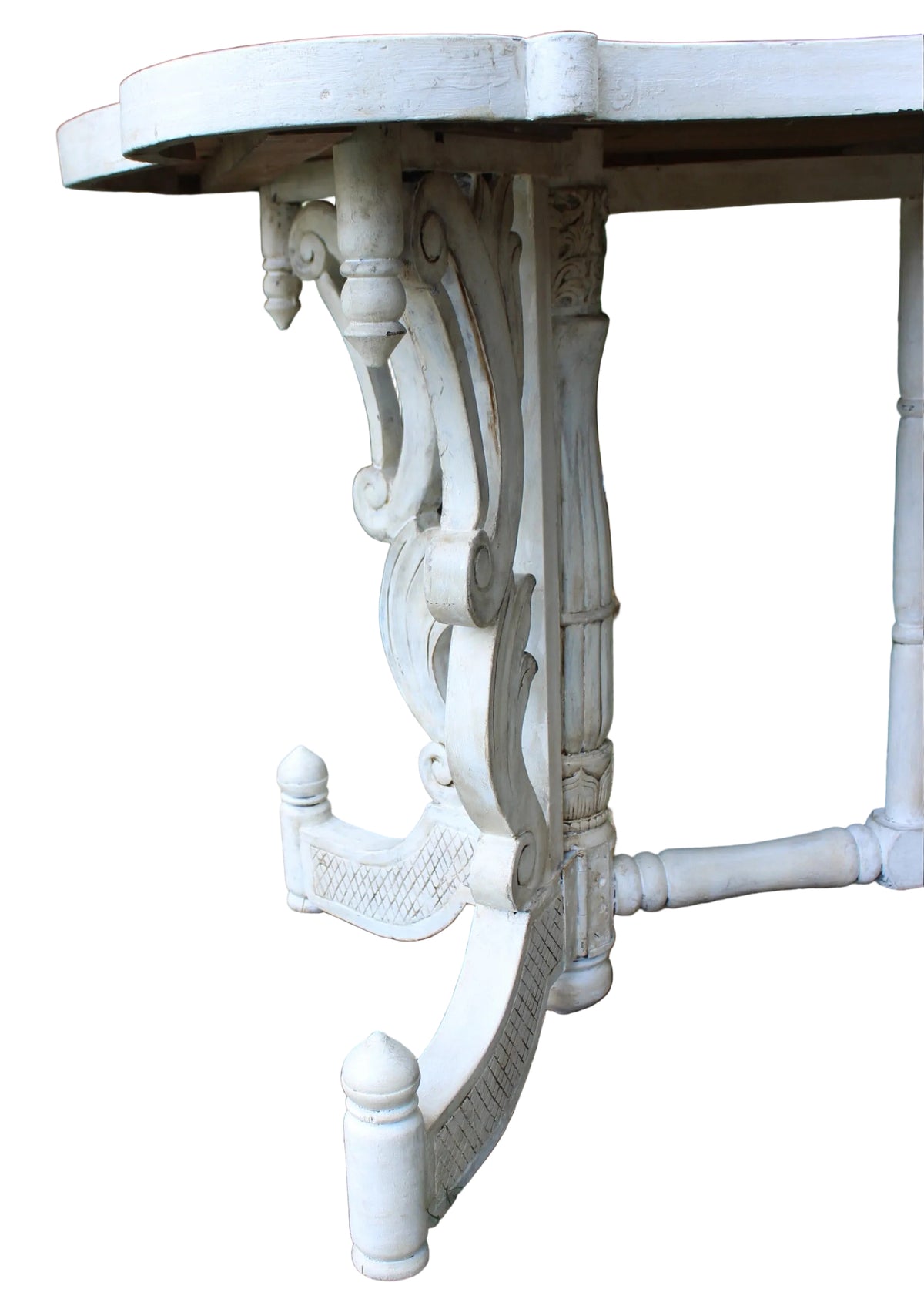 close-up outdoor shot of an ornate white carved table leg and part of the tabletop