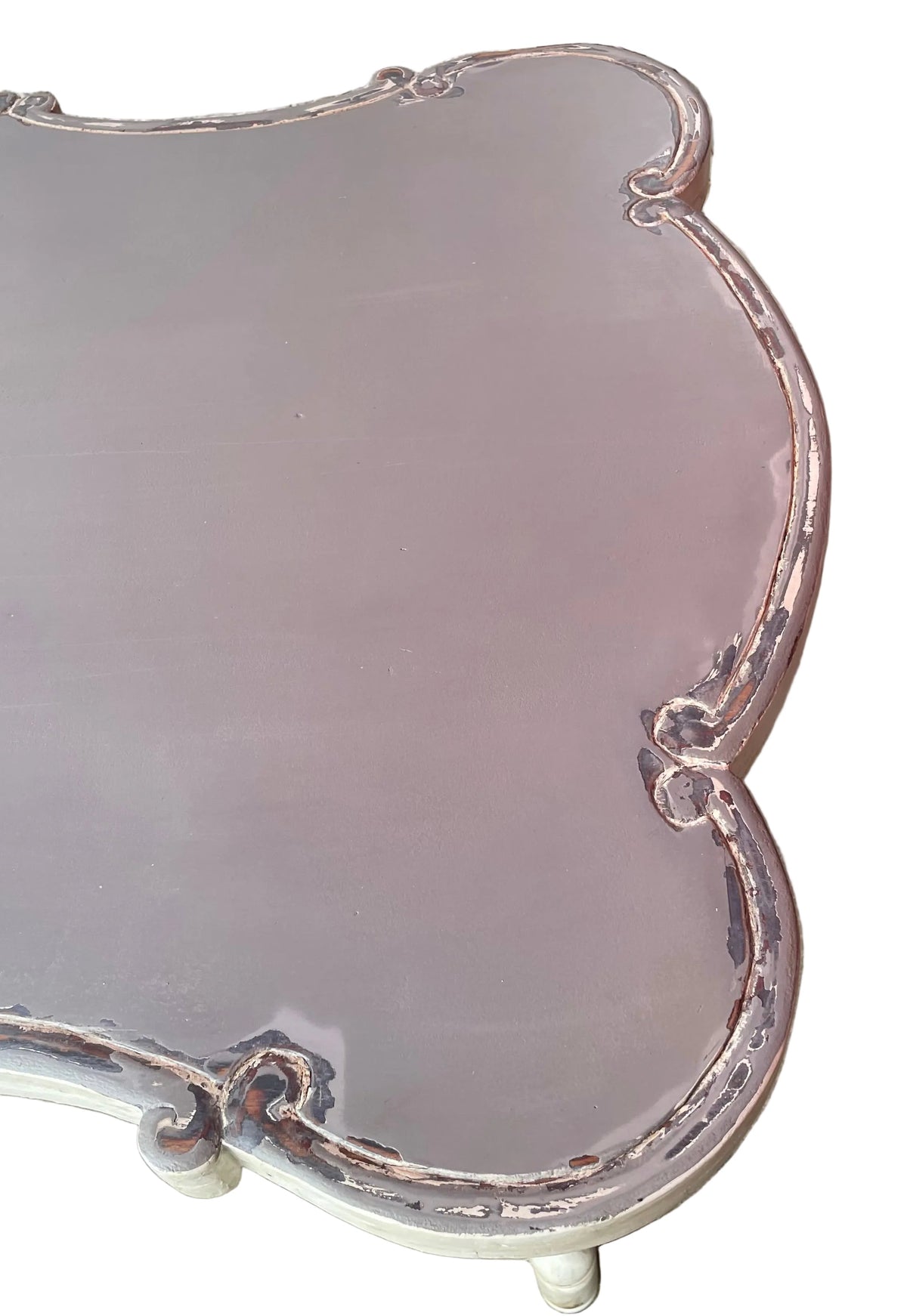 close-up of a distressed painted wooden table or bench with a scalloped edge