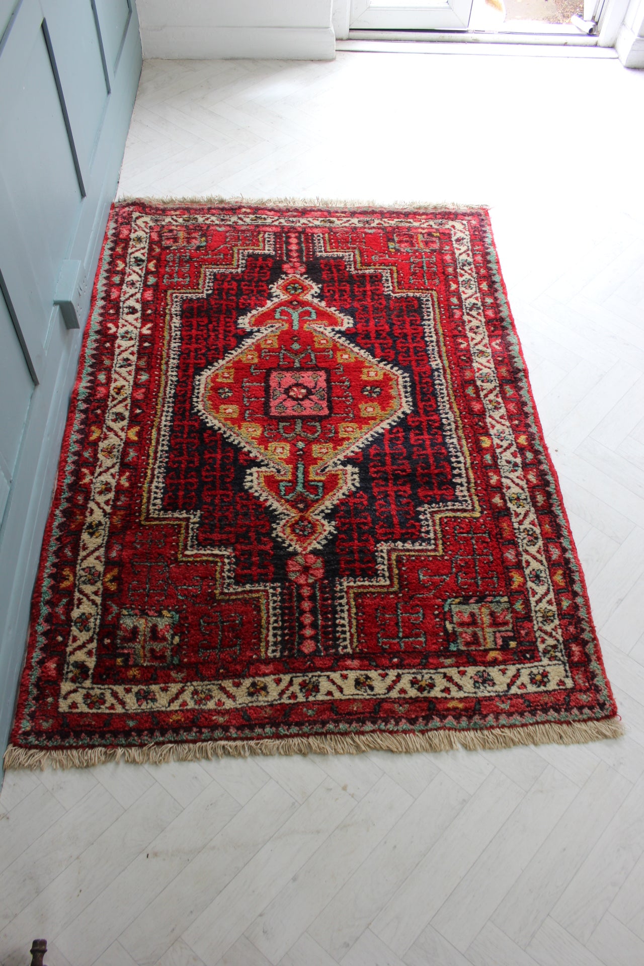 Close-up of hand-knotted Persian rug featuring intricate diamond medallion pattern and vibrant 1970s colors.