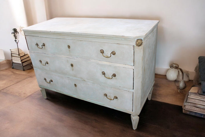 Detail of hand-painted floral motifs and brass handles on Gustavian chest