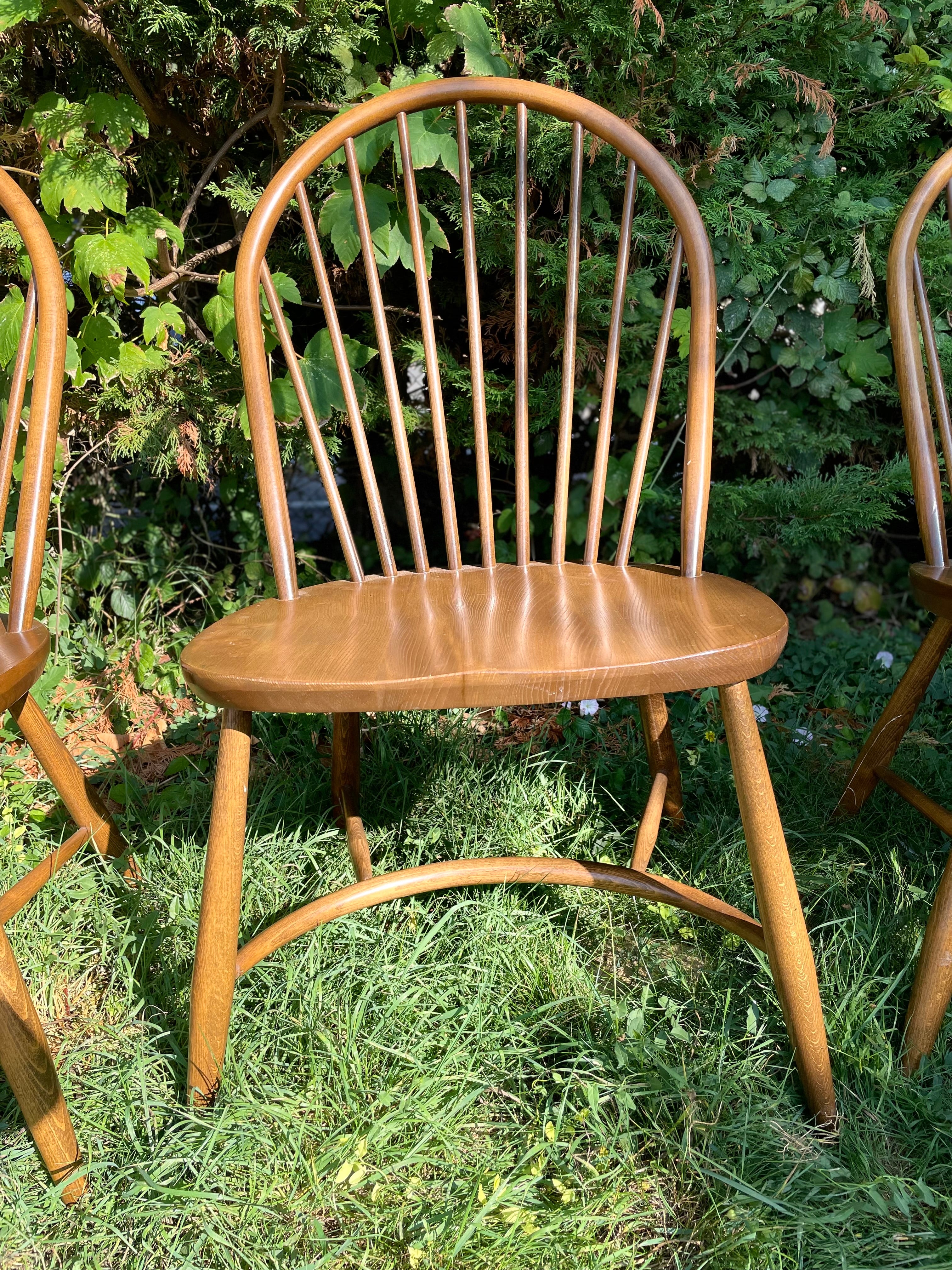 ERCOL LATIMER Wooden chair in a grassy outdoor setting with trees in the background