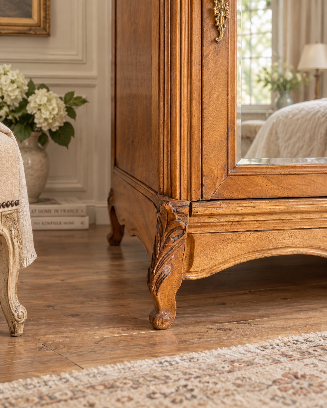 lose-up of carved cabriole leg detail on an early 20th century French walnut mirrored wardrobe