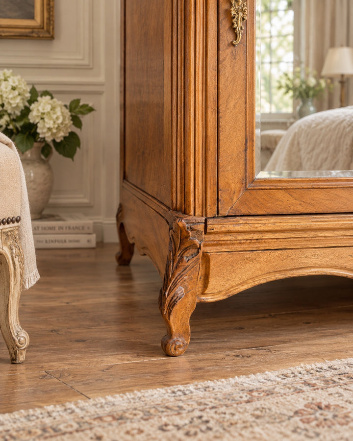 lose-up of carved cabriole leg detail on an early 20th century French walnut mirrored wardrobe