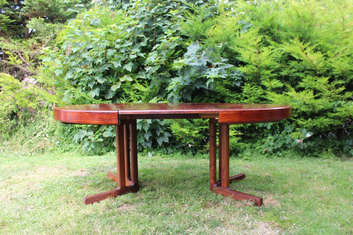 Expandable rosewood dining table showcasing fine wood grain and warm tones