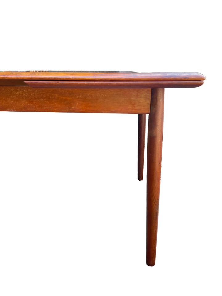 A mid-century modern wooden dining table with a warm reddish-brown finish End view