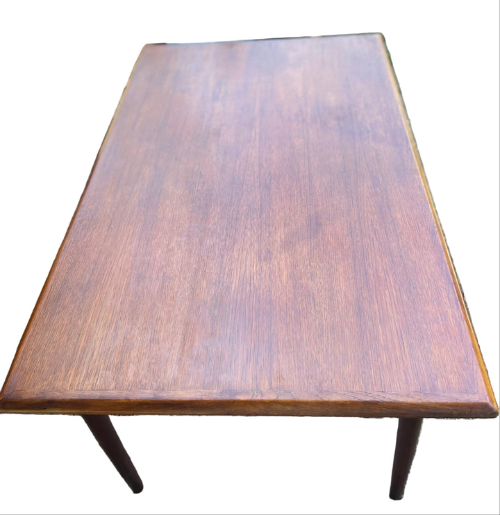 rectangular wooden table with a medium brown wood grain finish and tapered legs