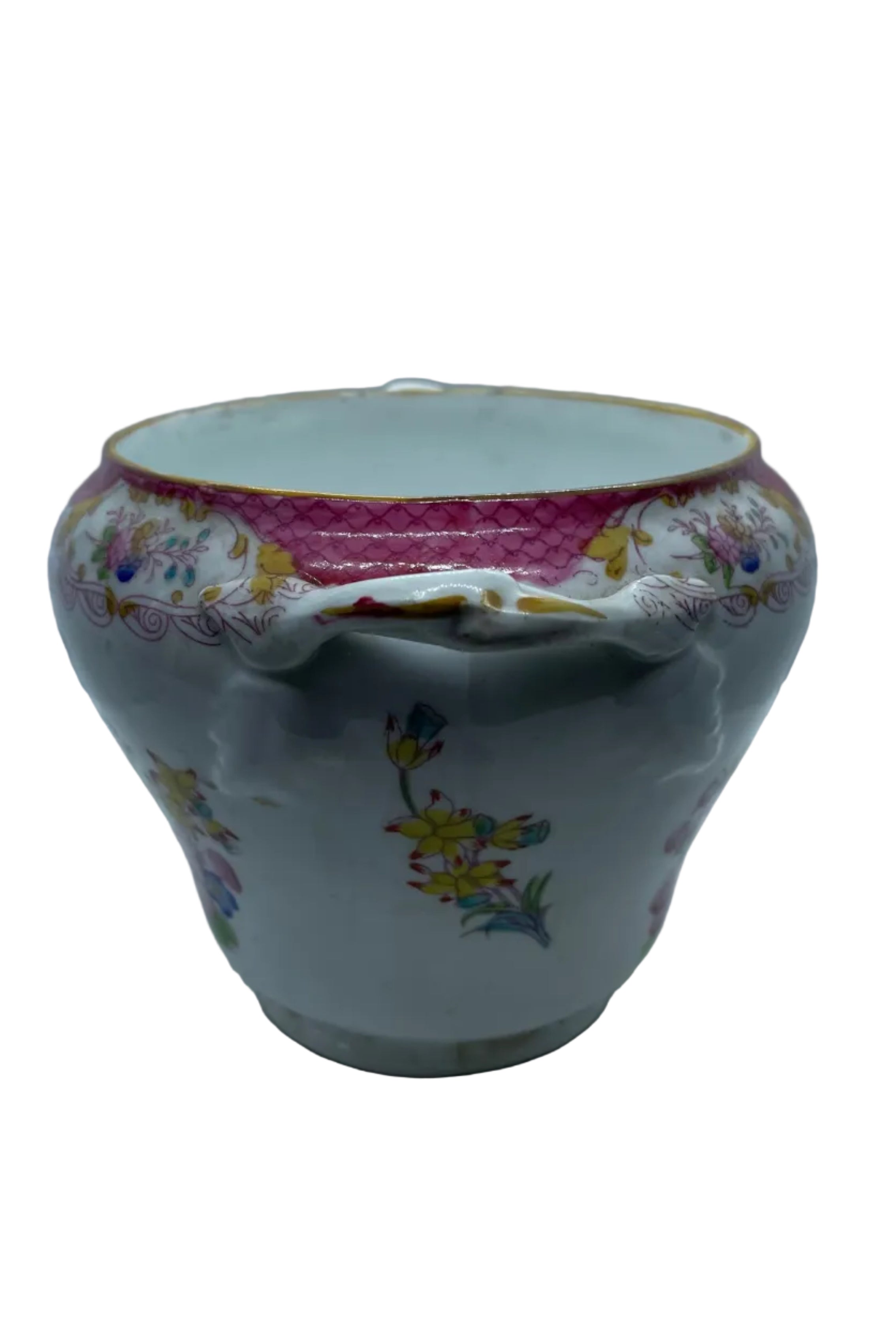 An antique porcelain cup with a wide rim, featuring a pink patterned inner band, a white outer body decorated with colorful floral motifs, and two side handles, set against a white background.
