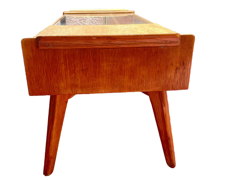 Wooden side table on a red and white patterned rug outdoors g plan