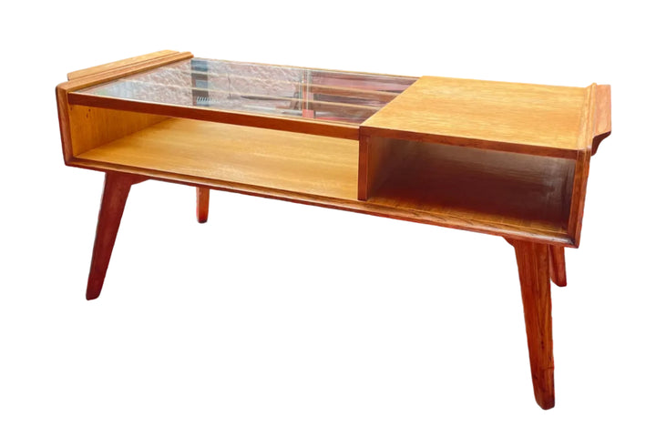Wooden g plan coffee table on a red and white patterned rug with a garden in the background