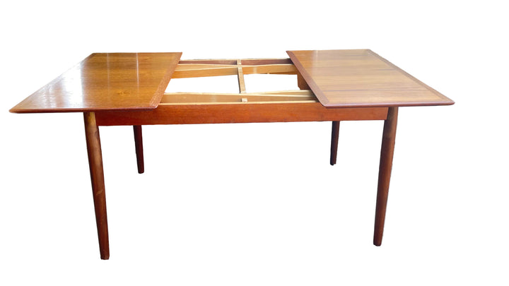 A midcentury teak dining table on a white background