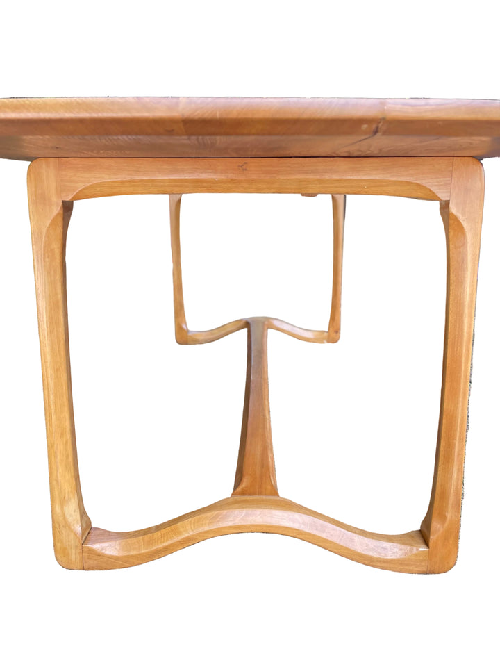 close-up of a wooden dining table base with a warm honey finish