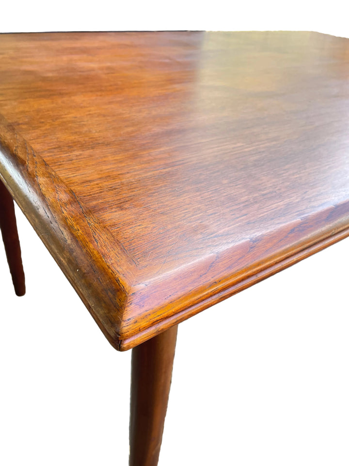 close-up view of a polished reddish-brown wooden table corner with a visible wood grain finish and a single leg