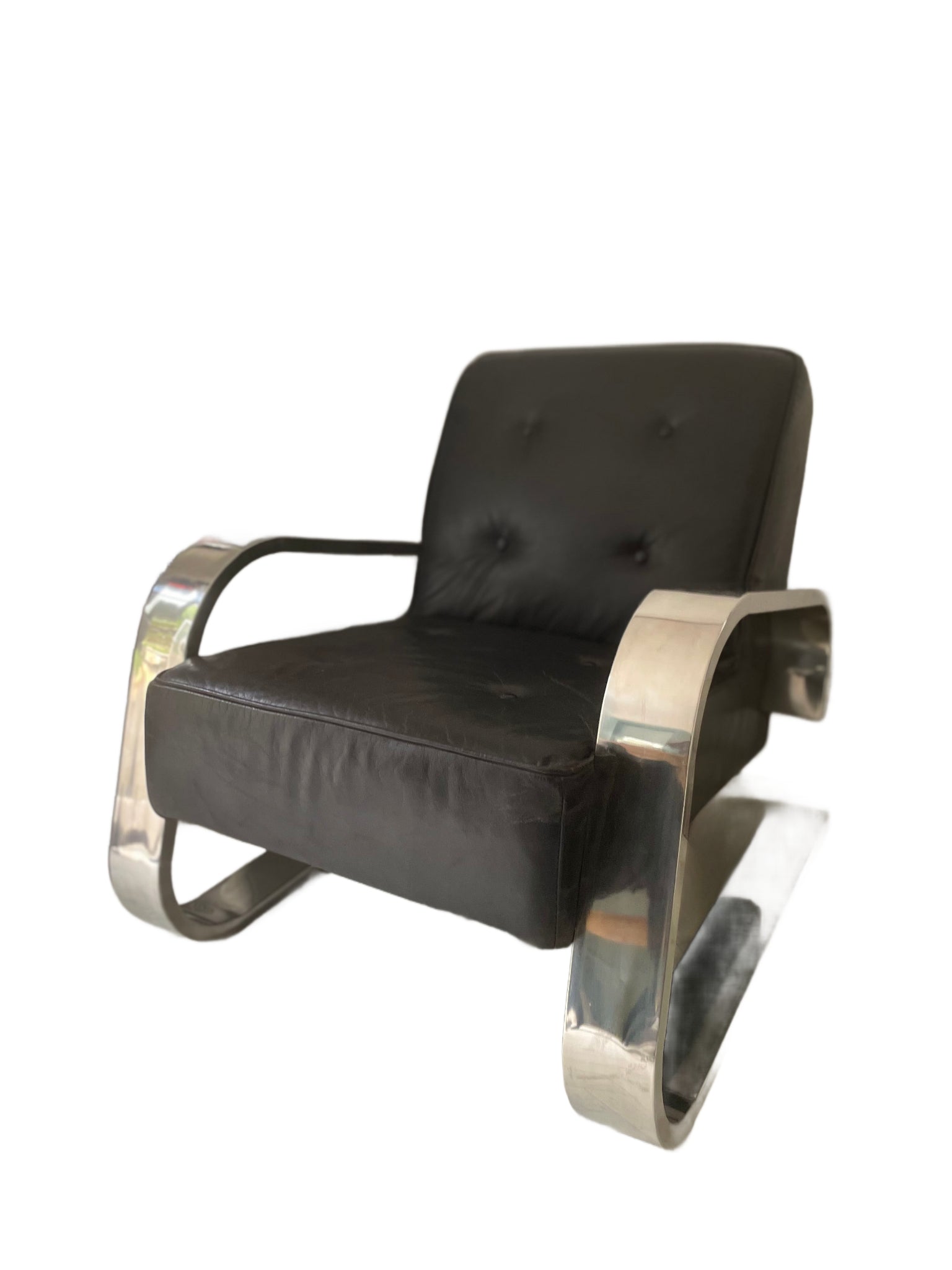 Angled front view of vintage cantilever chair with curved chrome arms and button-tufted leather