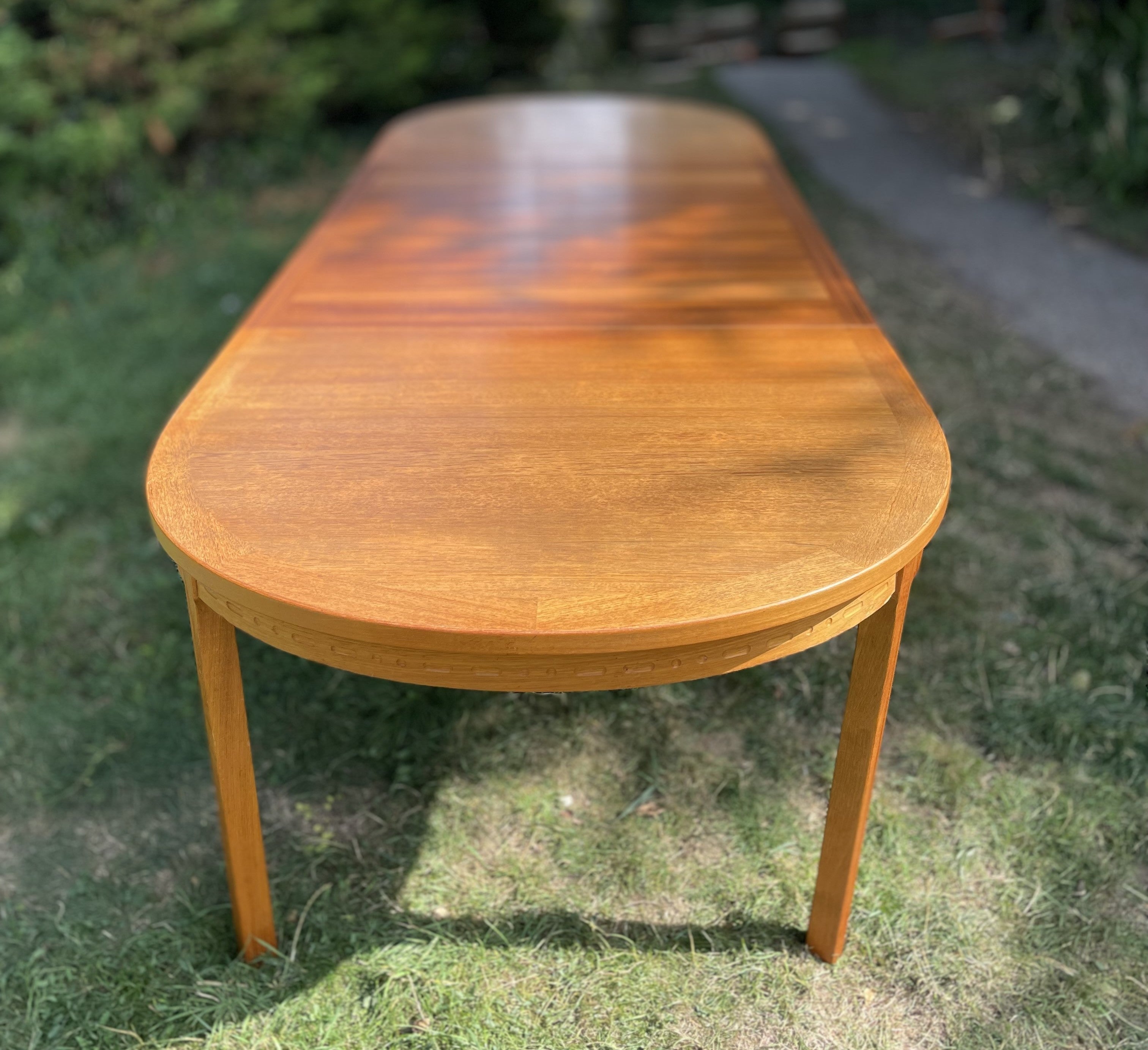 Wooden dining table on grass with a blurred background By Nils Jonsson for Troeds