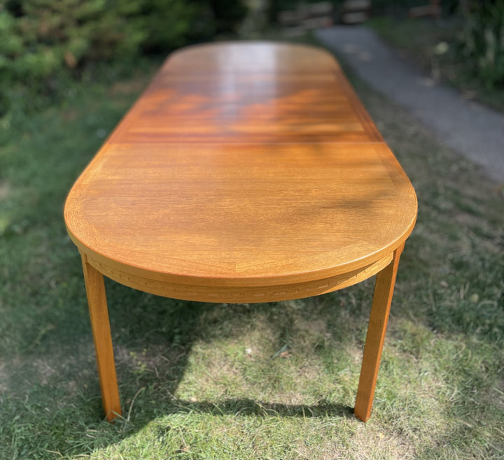 Wooden dining table on grass with a blurred background By Nils Jonsson for Troeds